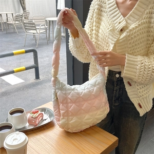 Close-up of pink gradient quilted cloud bag with padded texture and shoulder strap