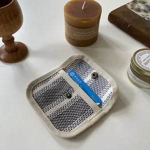 Close-up of woven canvas card holder with black and white check pattern and metal snap