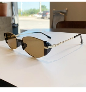 Dettaglio di occhiali da sole cat-eye vintage con stanghette in metallo dorato e lenti marroni a 45 gradi
