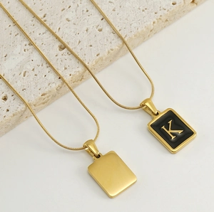 Détail de chaîne serpent en or 18k avec pendentif rectangulaire et lettre K en émail noir