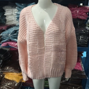 Detail of pink mohair cardigan showing thick cable knit texture and V-neck design