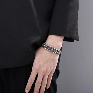 Close-up of vintage titanium steel bracelet with ethnic totem carvings on a male wrist