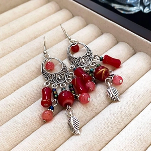 Dettaglio orecchini pendenti argento con perline rosse e foglie in astuccio