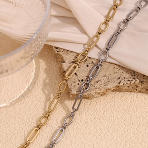 Minimalist 14K gold and silver stainless steel paperclip chain anklet on silk background