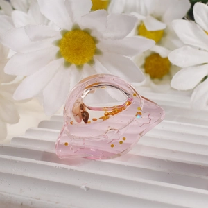 Detalle de pinza para el pelo de resina rosa con pan de oro y concha incrustada