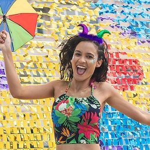 Model wearing a purple gold and green Mardi Gras headband with feathers and sequins