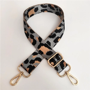 Close-up of leopard print wide strap with golden metal hooks and adjustable buckle detail