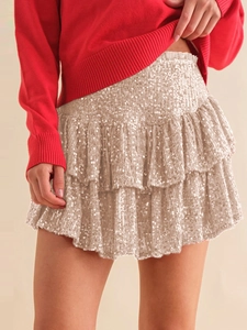 Macro shot of tiered champagne gold sequins and fabric texture on a mini skirt