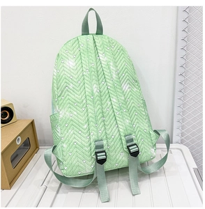 Detalle de mochila acolchada verde con patrones de corazones y correas ajustables