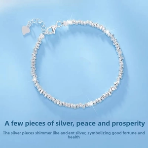 Detail view of S999 sterling silver bracelet with irregular nuggets and heart charm