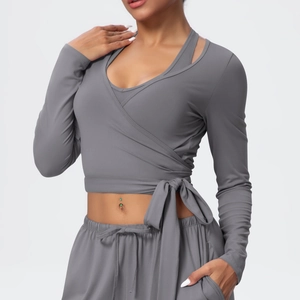 Detailed view of gray yoga top featuring cross-wrap tie design and built-in sports vest