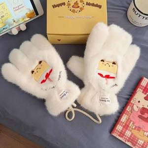 Nahaufnahme weißer Plüschhandschuhe mit niedlichen Toast-Aufnähern und roten Schleifen