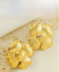 Macro shot of French vintage gold floral earrings with ribbed texture and spherical center