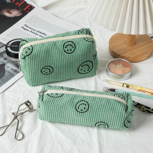 Detailed close-up of mint green corduroy pouch set with smiley face embroidery