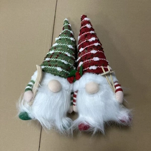 Detailed close-up of handmade Christmas gnomes plush set with knitted hats and wooden props