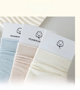Detail der hochelastischen Rippbündchen an pastellfarbenen Socken in Blau, Rosa und Beige