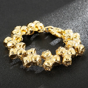 Detailed view of the interlocking gold-tone skull links on this vintage steel bracelet