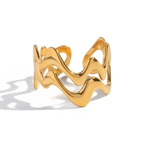 Détails macro des lignes ondulées doubles sur la bague ajustable dorée et polie