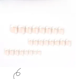 Detailed flat lay of 24 pieces short French press-on nails with white tips and gold lines