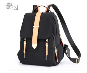 Detail side view of black nylon backpack featuring contrast orange webbing and gold buckles