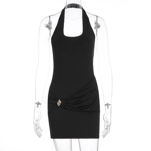 Detail of black halter mini dress featuring side ruching and metallic buckle ornament