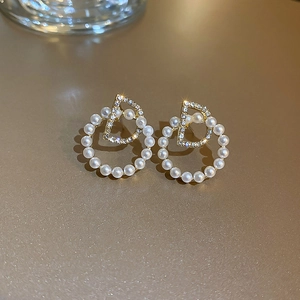 Vue détaillée des boucles d'oreilles perles dorées avec lettre D et cristaux pavés