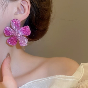 Detailed view of large pink crystal flower earring worn by model for elegant style