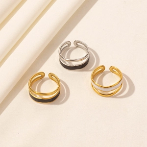Detailed view of layered stainless steel rings with black and white enamel inlays