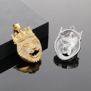 Goldene und silberne Löwenkopf-Anhänger mit Kristallen auf glänzend schwarzer Fläche