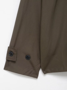 Detailed view of olive trench coat cuff with adjustable strap and two black buttons