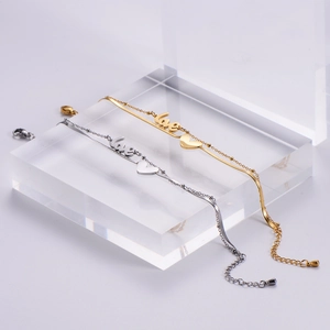 Detail of love pendant bracelet with snake and bead chain on acrylic stand