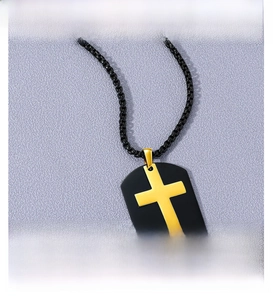 Polished gold cross pendant on matte black rectangular tag with stainless steel box chain