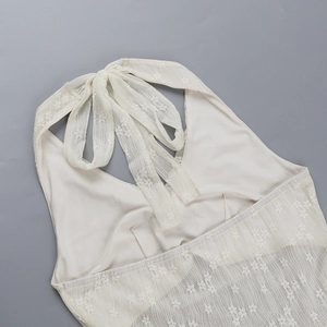 Detailed close-up of lace halter neckline and tie-up design on backless mini dress