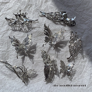 Close-up of liquid metal silver butterfly hair claw clips on textured white paper