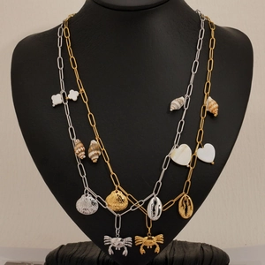 Ocean themed necklace with gold and silver shells, crabs, and conch charms on beach style