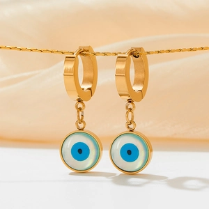 Créoles dorées avec pendentifs oeil du diable en perles sur fond de soie beige