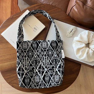 Macro view of embroidery patterns and simple wish woven label on the canvas tote bag