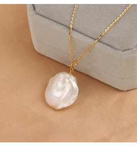 Close-up of a baroque pearl pendant on a gold S925 sterling silver chain in a jewelry box