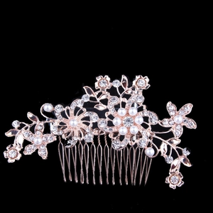 Close-up of rose gold bridal hair comb with floral rhinestones and white pearls