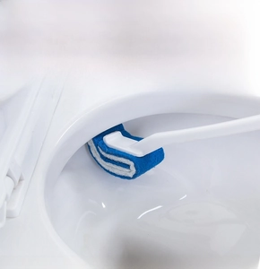 Curved toilet brush head cleaning the hard-to-reach inner rim of a white ceramic toilet