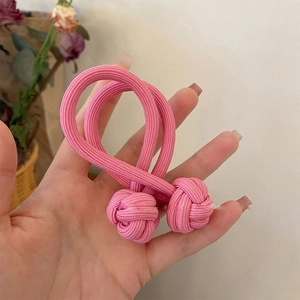 Close-up of pink high-elasticity hair tie with a decorative Chinese knot design