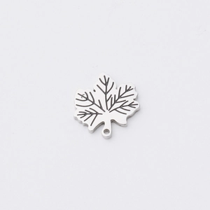 Macro detail of mirror stainless steel maple leaf pendant with etched vein patterns