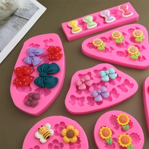 Pink silicone mold set featuring sunflower, bee, and bow shapes for DIY cake decor
