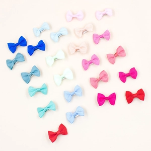 Flat lay of colorful handmade grosgrain ribbon bow hair clips in a diverse color gradient