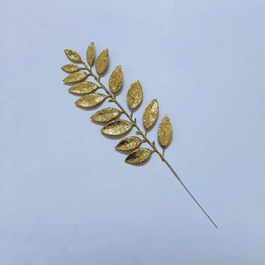 Detail of golden glitter artificial leaf branch for Christmas and festive home decoration