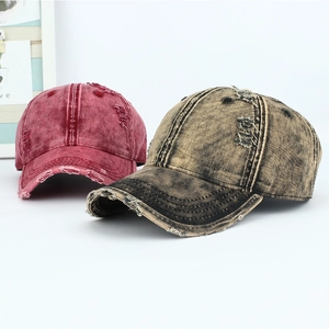Close-up of vintage distressed denim baseball caps with frayed holes and washed textures