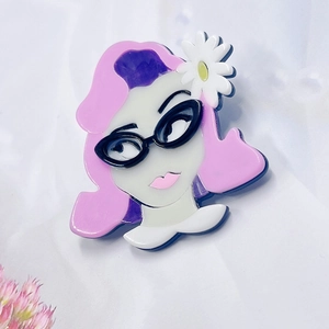 Acrylic daisy girl brooch with pink and purple hair wearing black cat-eye glasses