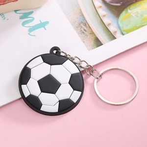 Close-up of a classic black and white PVC soccer ball keychain with silver metal ring