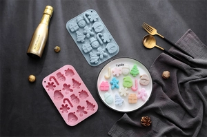Detailed view of blue and pink silicone molds with festive Christmas theme shapes
