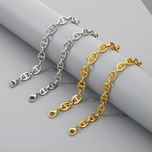 Polished gold and silver pig nose oval link chains hanging on gray display props